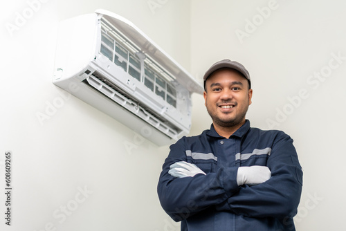 Air conditioner service indoors. Air conditioner cleaning technician He opened the front cover and took out the filters and washed it. He in uniform wearing rubber photo