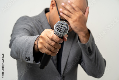 Businessman speaker with high quality dynamic microphone speaking talking with people on isolated white background. Male testing microphone voice for interview. Motivation life coach in training
