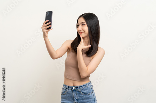 Happy Beautiful young asian woman using smartphone mobile to selfie take photo herself standing on isolated white background.