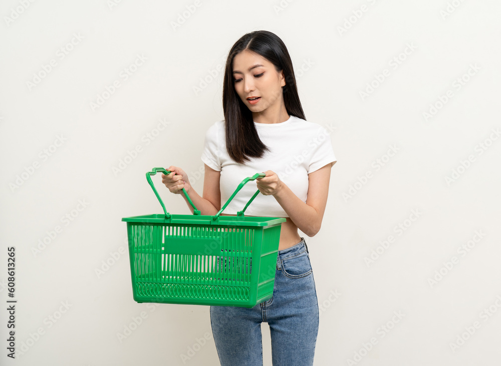 Happy beautiful woman holding shopping basket. Portrait beautiful asian female in fashion style standing pose on isolated background. Young asian woman shopping at online market application Happy beautiful woman holding shopping basket. Portrait beautiful asian female in fashion style standing pose on isolated background. Young asian woman shopping at online market application