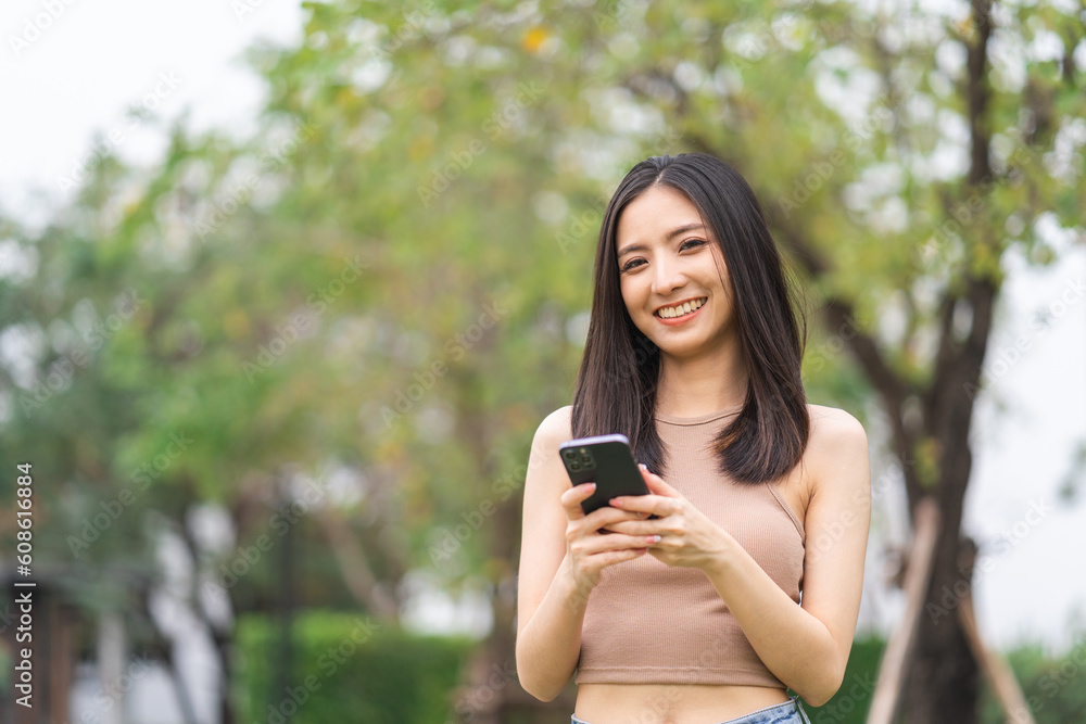 Happy feeling of beautiful Young woman using and text on smartphone. She shopping online. She smile very happy. Teenage girl reading news from mobile cell phone feeling excited.