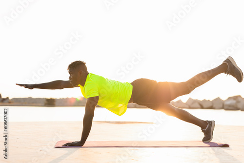 Fitness training outdoors. Handsome African man doing exercises outside. Muscular man training.