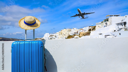Fototapeta Naklejka Na Ścianę i Meble -  Blue luggage and hat as landscape view of Oia town in Santorini island in Greece , Greek landscape as blue sky background