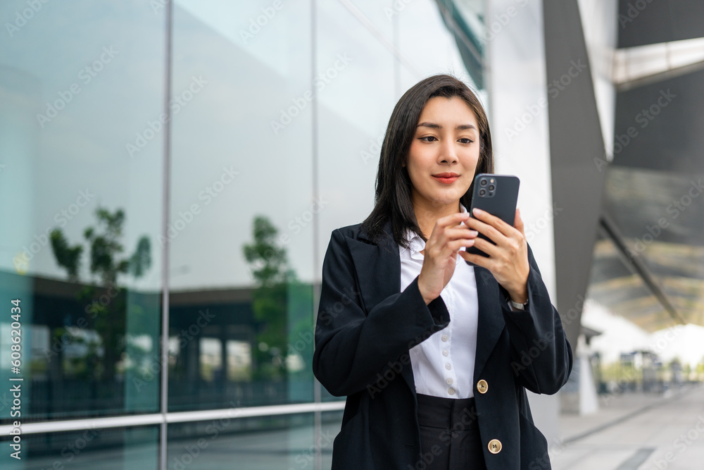 Portrait beautiful Businesswoman in suit with smartphone standing at the buildings downtown. Confident woman using cellphone. Executive Smart businessman Portrait beautiful Businesswoman in suit with smartphone standing at the buildings downtown. Confident woman using cellphone. Executive Smart businessman