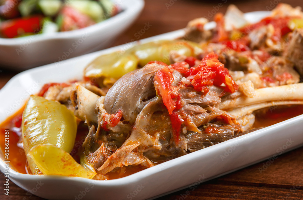 Khashlama is popular Armenian dish, which is prepared from beef with vegetables. Khashlama in the plate. stewed lamb on the bone with vegetables on wooden desk Khashlama is popular Armenian dish, which is prepared from beef with vegetables. Khashlama in the plate. stewed lamb on the bone with vegetables on wooden desk