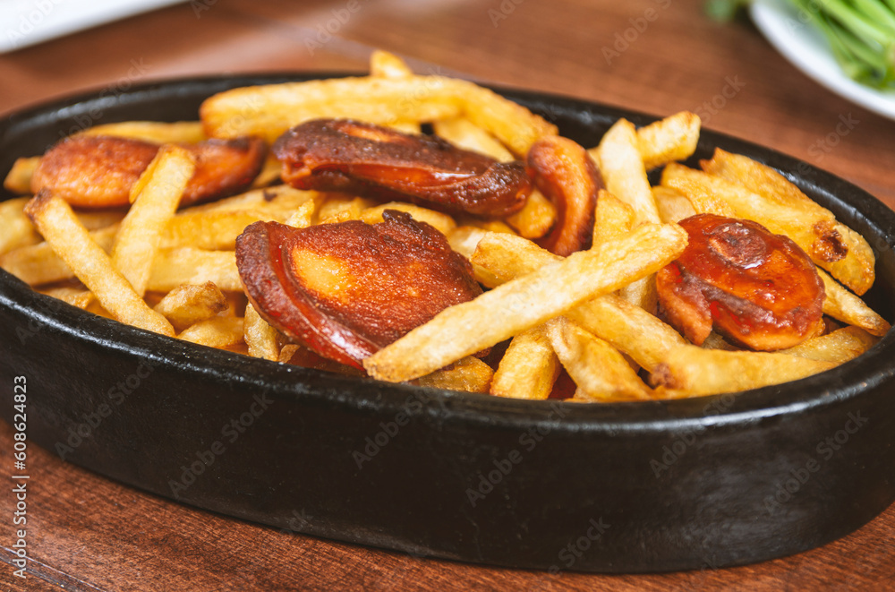 Frying pan with pieces fried sausage and potato Frying pan with pieces fried sausage and potato
