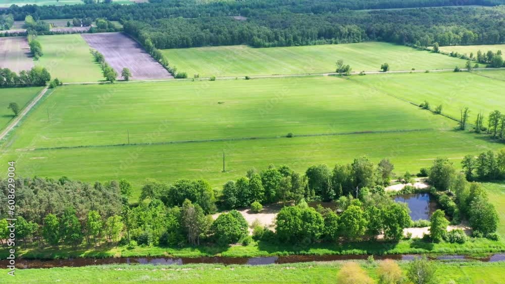 Aerial view of flat landscape intensively used by meadows and fields next to straightened river Ise near Gifhorn, Germany Aerial view of flat landscape intensively used by meadows and fields next to straightened river Ise near Gifhorn, Germany