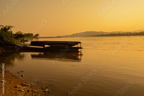 View of the morning Mekong River surrounded by mountains and yellow sunbeams in the sunset background at Chiang Khong, Chiang Rai, northern Thailand. 