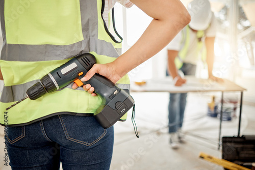 Construction, handyman and drill in hand for maintenance or carpenter work. Back of engineer, constructor or contractor person with electric power tools at building site for home renovation project