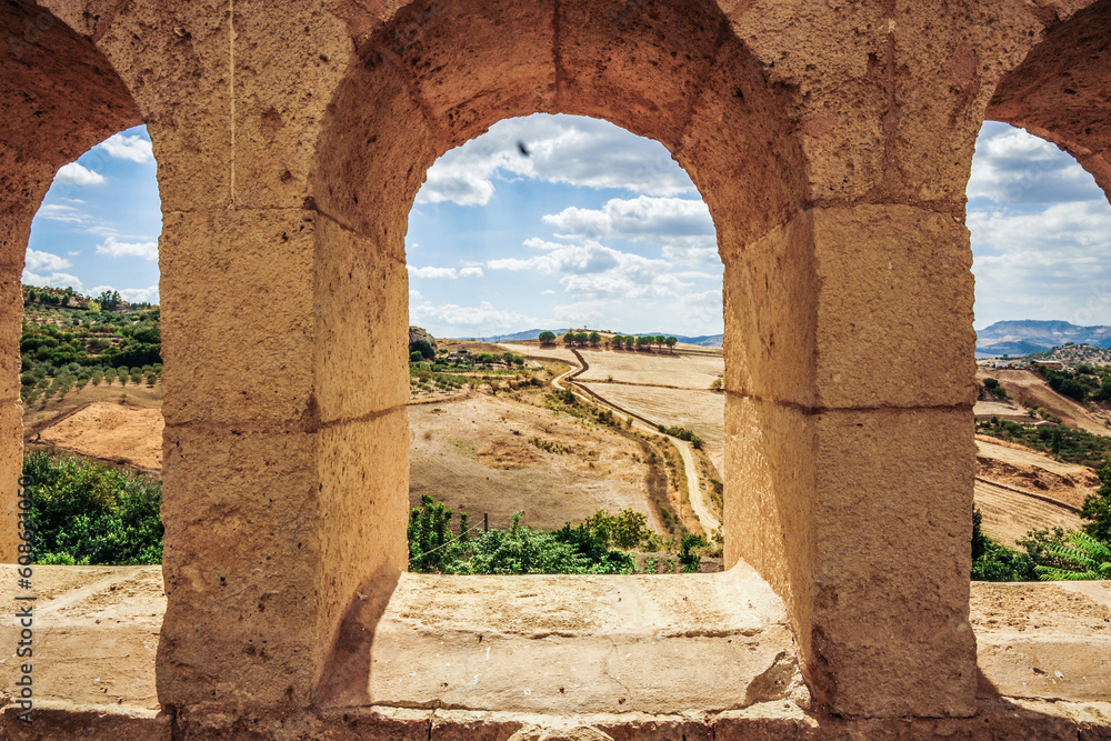 view of a field through an arc at a Sicily ancient town 
