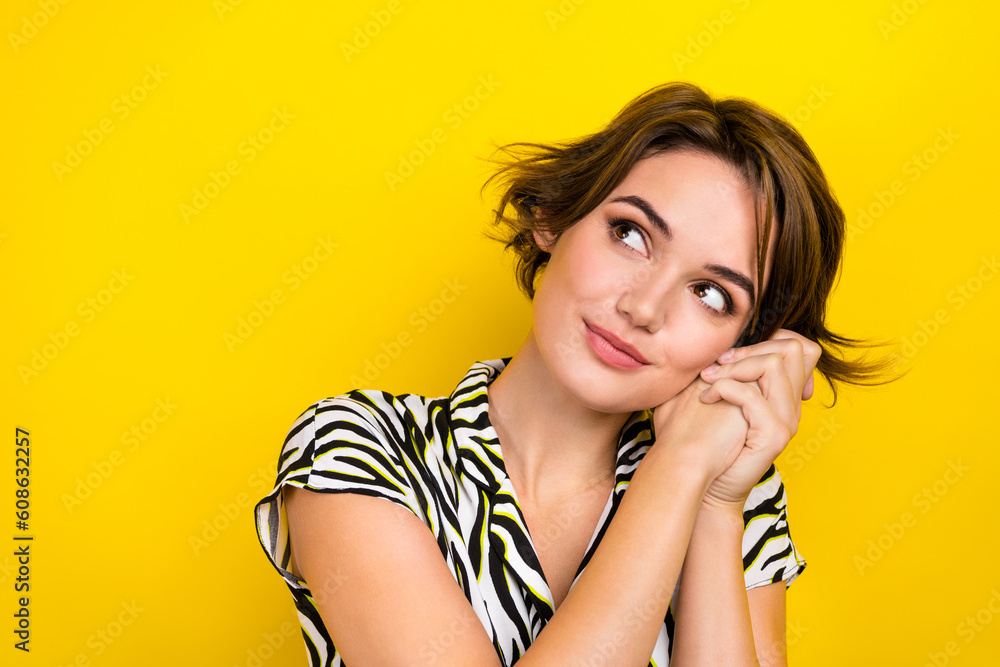 Closeup photo of adorable dreamy girl hold hands near face look empty space wear print blouse isolated yellow color background Closeup photo of adorable dreamy girl hold hands near face look empty space wear print blouse isolated yellow color background