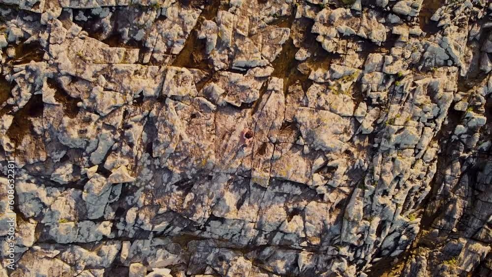 Person Isolated On The Rocky Cliffs Of Arteixo, La Coruna, Galicia, Spain. Aerial Drone Ascending Person Isolated On The Rocky Cliffs Of Arteixo, La Coruna, Galicia, Spain. Aerial Drone Ascending