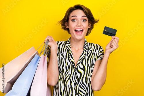 Photo of crazy astonished impressed girl with bob hairdo hold plastic card buy new outfit online isolated on yellow color background