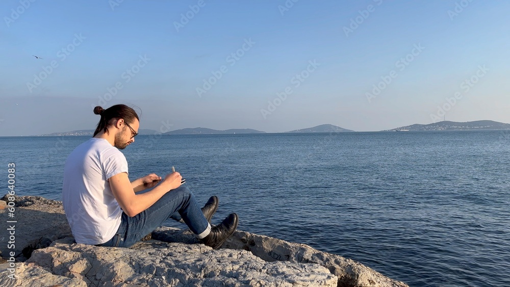 sitting man works near the sea	
