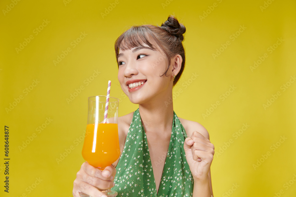 Beautiful young woman with orange juice on yellow background Beautiful young woman with orange juice on yellow background