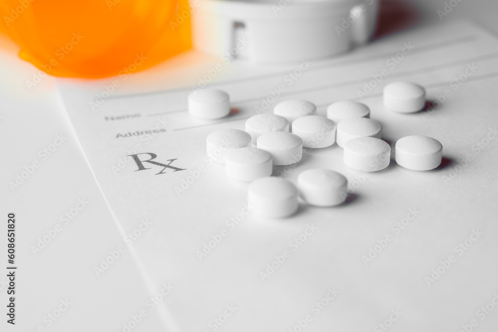 white prescription pills laying on rx pad on white background - obrazy, fototapety, plakaty 