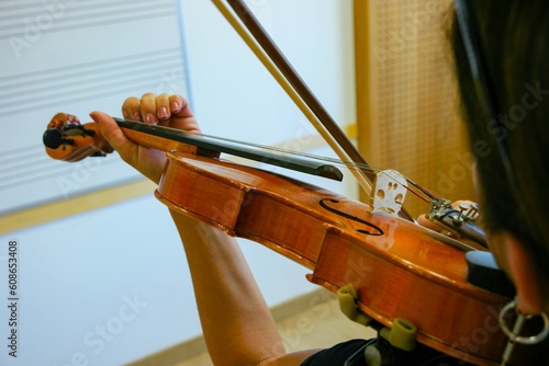 Primer plano de una alumna de violín tocando su instrumento en una clase de música. photo