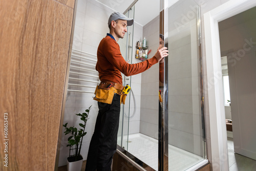 Plumber installing a shower cabin in bathroom