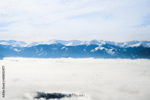 View from Cerenova skala (rock) in West Tatras in Liptov. Near Liptovsky Mikulas city in foggy weather. Spring time, cloudy weather, Slovakia. Green forest. Village in the fog.