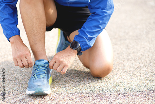 Running shoes. Barefoot running shoes close up. male athlete sitting tying laces for jogging on road. Runner ties getting ready for training. Sport lifestyle. Sunny in the morning.