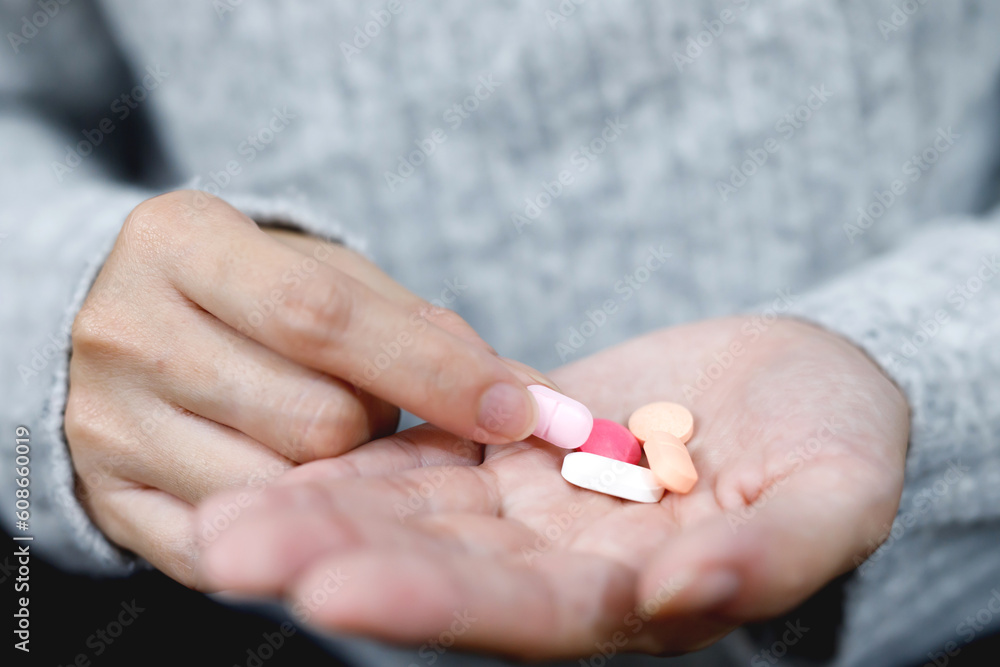 close up hand woman holding taking multiple pills. Stop drug use Taking Medication health care medical concept. close up hand woman holding taking multiple pills. Stop drug use Taking Medication health care medical concept.