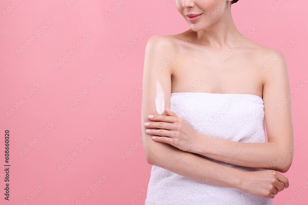 Woman with smear of body cream on her arm against pink background, closeup. Space for text Woman with smear of body cream on her arm against pink background, closeup. Space for text
