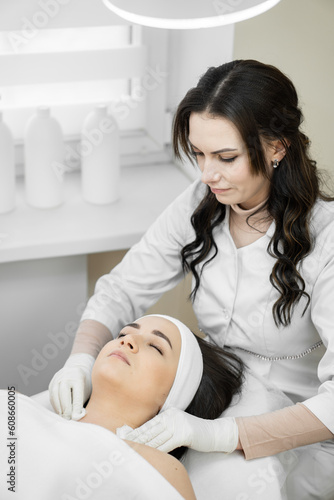 Give your face to professionals: cosmetology in action, when a woman trusts her face to professionals who carry out effective cleansing and skin care in a cosmetic clinic at a cosmetologist