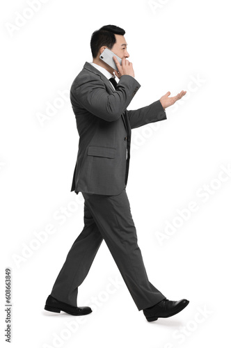 Businessman in suit talking on phone against white background