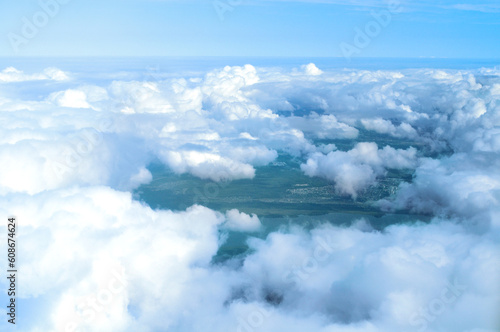 View from height of white dense clouds floating over land surface