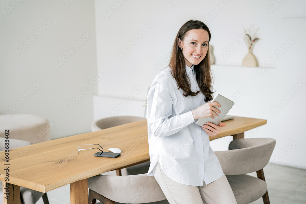 Female programmer student in a blue shirt. Uses a laptop and tablet workplace in a new bright office. My favorite hobby is surfing the Internet. Female programmer student in a blue shirt. Uses a laptop and tablet workplace in a new bright office. My favorite hobby is surfing the Internet.
