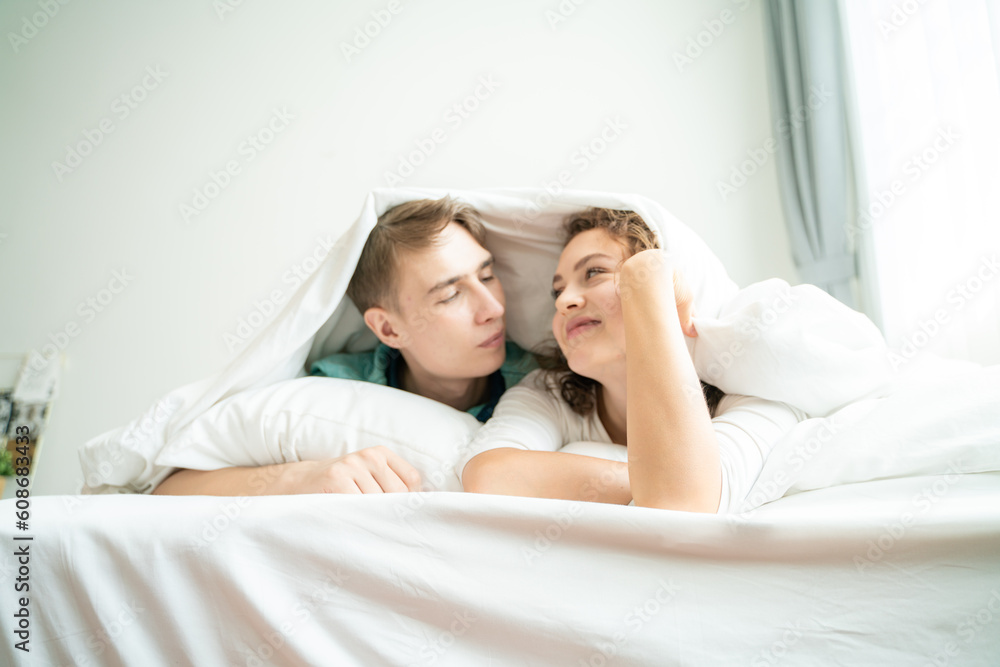 antic love couple man woman lying on white bed morning wake up honeymoon antic love couple man woman lying on white bed morning wake up honeymoon