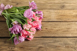 Beautiful bouquet of colorful tulip flowers on wooden table, space for text