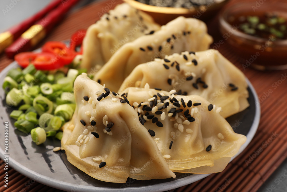 Delicious gyoza (asian dumplings) with sesame seeds on table, closeup