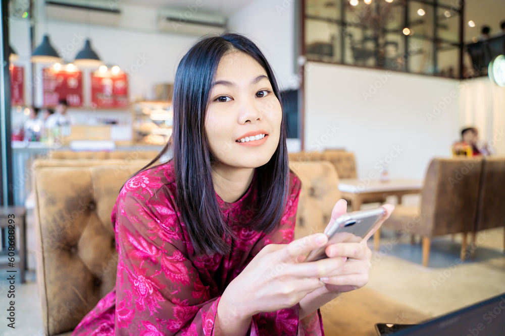 Business asian woman in casual use smartphone sitting in coffee shop Business asian woman in casual use smartphone sitting in coffee shop