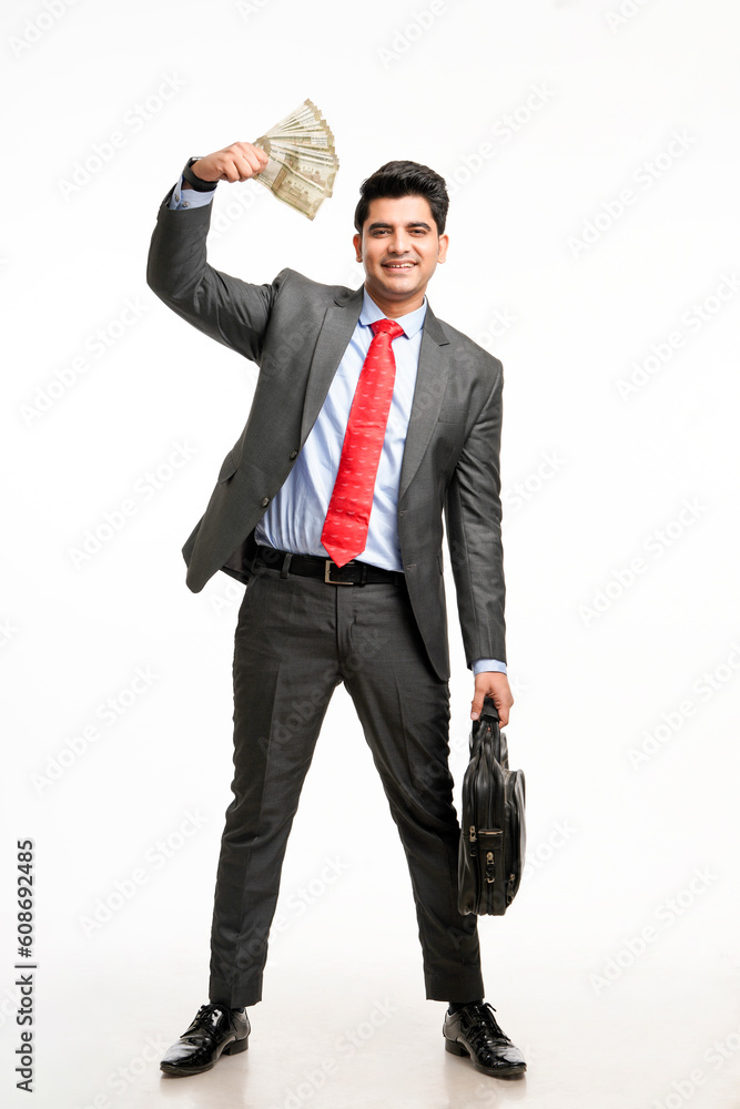 Young indian man in suit and showing indian rupees on white background. Young indian man in suit and showing indian rupees on white background.