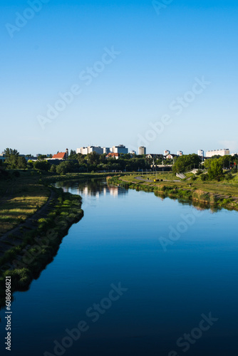 Vertical photo of a blue river in the distance with the cityscape. Top view