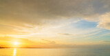 Sunset sky clouds over sea in the evening with yellow, orange sunlight on Golden Sky hour, Horizon sea landscape background on summer 