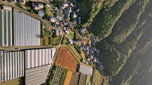 Vertical aerial view of a small town along the mountains feet, Susaki, Shikoku Island, Kochi, Japan. photo