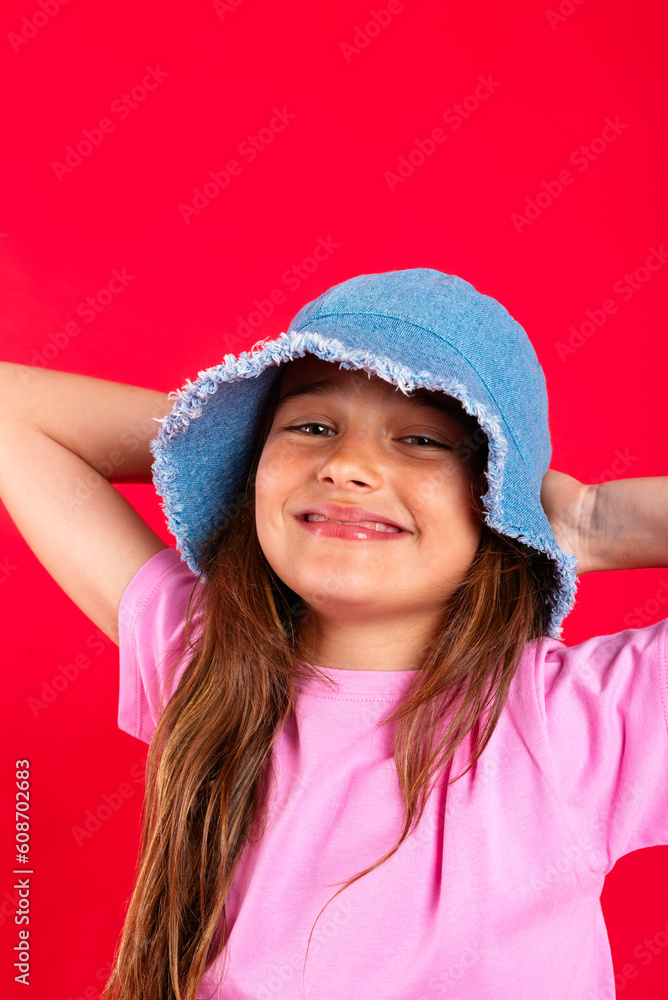 Adorable girl in hat over red background Adorable girl in hat over red background