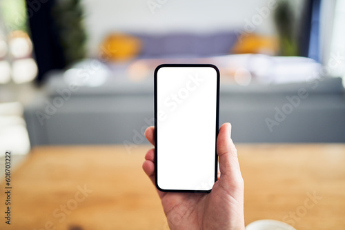 Hand holding smartphone with blank screen