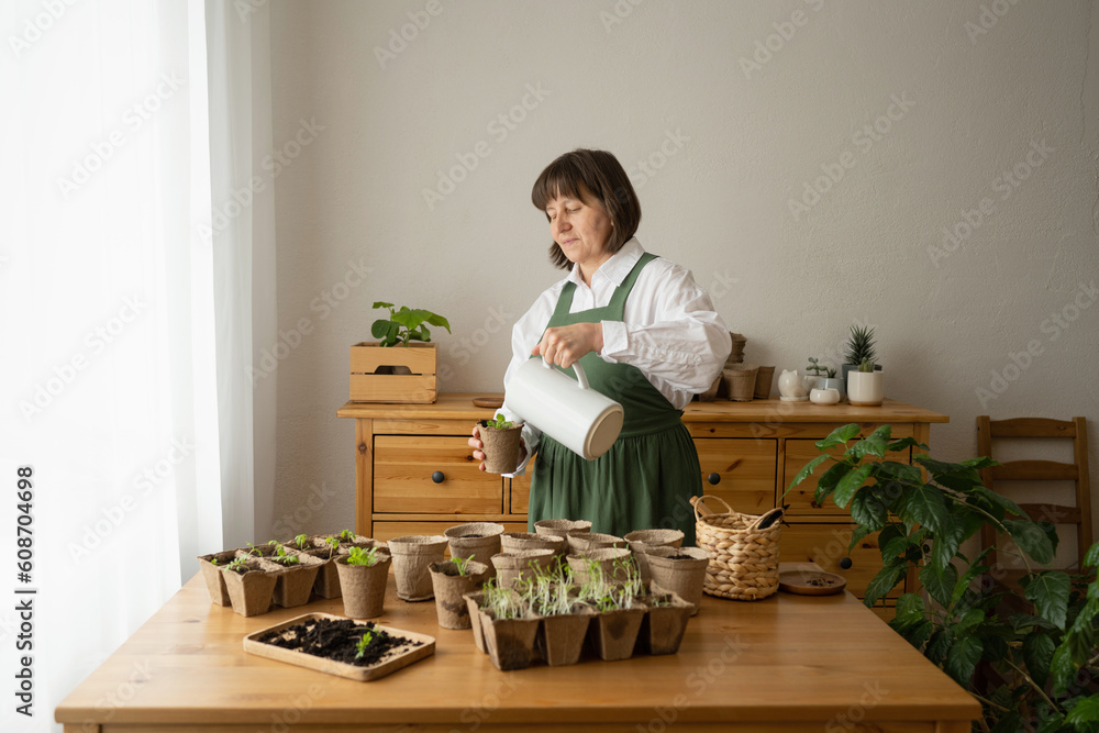 Grandmother working on potted plants over table at home Grandmother working on potted plants over table at home