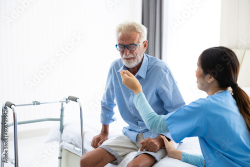 Elderly caucasian man patient bored  unhappy and sad eating food offered by asian woman nurse at home care.