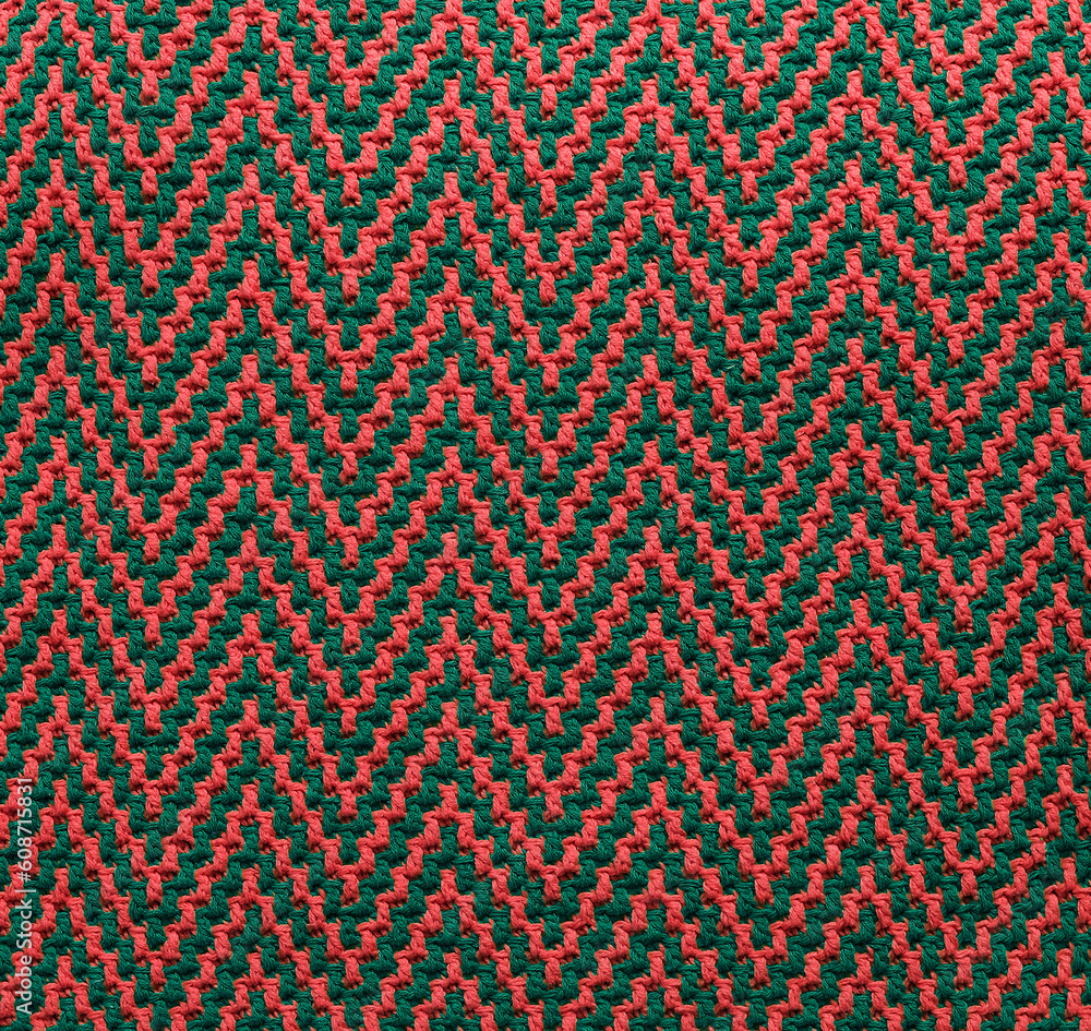 Knitted texture with chevron pattern. Texture of mosaic fabric with pink green geometric ethnic pattern. Crochet mosaic pattern. Knitted texture with chevron pattern. Texture of mosaic fabric with pink green geometric ethnic pattern. Crochet mosaic pattern.