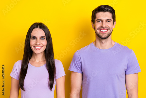 Portrait of two friendly cheerful people beaming smile have good mood isolated on yellow color background © deagreez