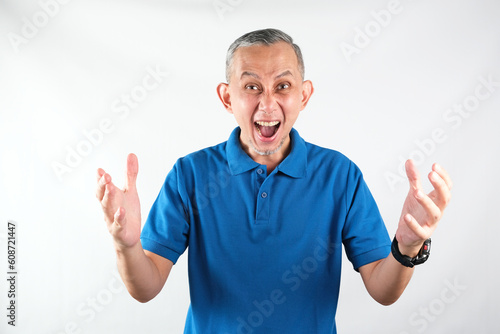 Portrait of Asian Man angry and desperate, screaming and looking outraged
 photo