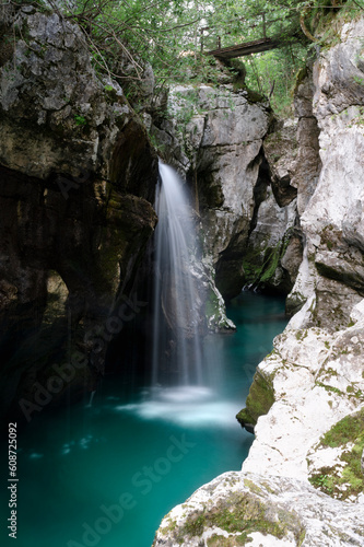 Blurred image of a beautiful short waterfall in big gorge of the river Soca