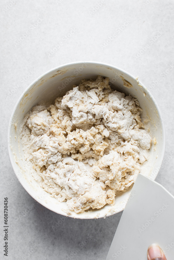 Loosely folded bread dough in a white bowl, bread dough, low hydration dough, process of making bread
