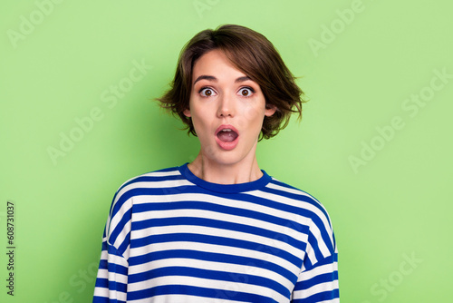 Photo of astonished impressed woman with bob hairstyle dressed sailor shirt astonished staring at sale isolated on green color background