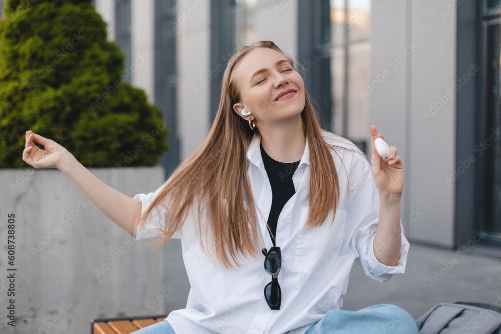 Music, dance and motivation with a business woman walking near office while feeling positive or carefree. Success, happy or smile with woman employee sitting near work in headphones with a smile. Win. Music, dance and motivation with a business woman walking near office while feeling positive or carefree. Success, happy or smile with woman employee sitting near work in headphones with a smile. Win.