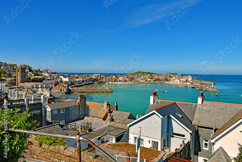A beautiful panorama of St Ives Cornwall in the U.K. with blue sky blue sea with the jetty harbour and pretty  lighthouse in the background
